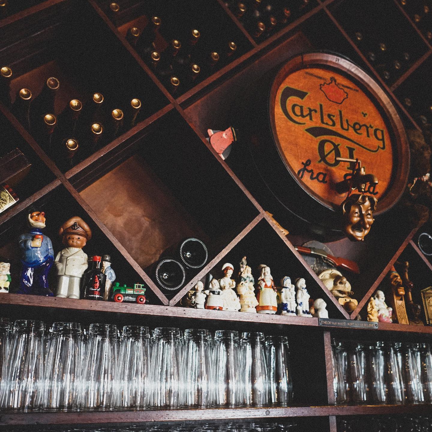 Carlsberg-tønden og vinreolerne bag baren